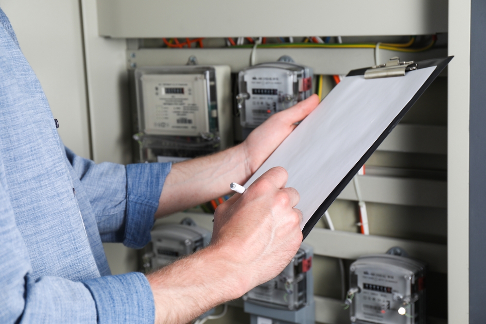 Electrical technician providing an electrical inspection with clipboard