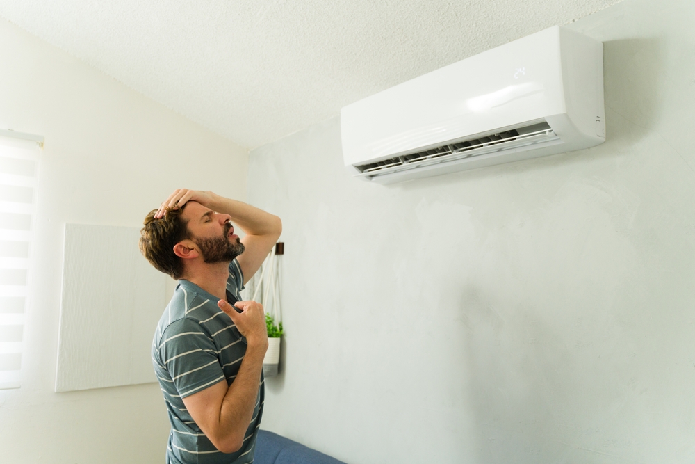 Man cooling off in front of a mini split in his home