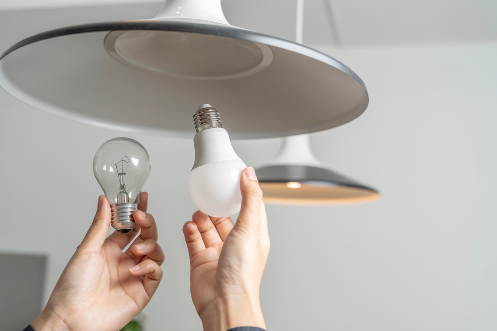 Person swapping out an old light bulb for a new one