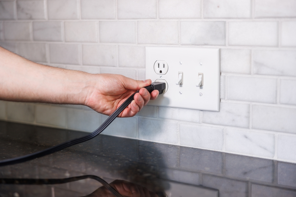 electrical outlet with cord plugged in on wall